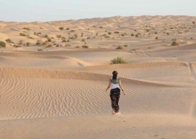 Frau in einer Sandwüste von Dünen umgeben
