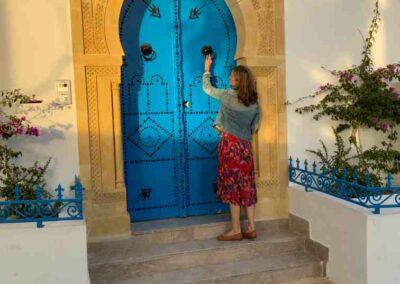 Frau steht vo einem orientalischen Tor und Haustür mit Bogen und blau gestrichen