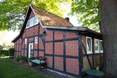 Historisches Niedersachsenhaus in einem Garten unter Bäumen