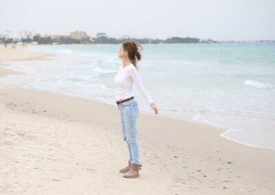 Frau am Strand in Stretching Pose