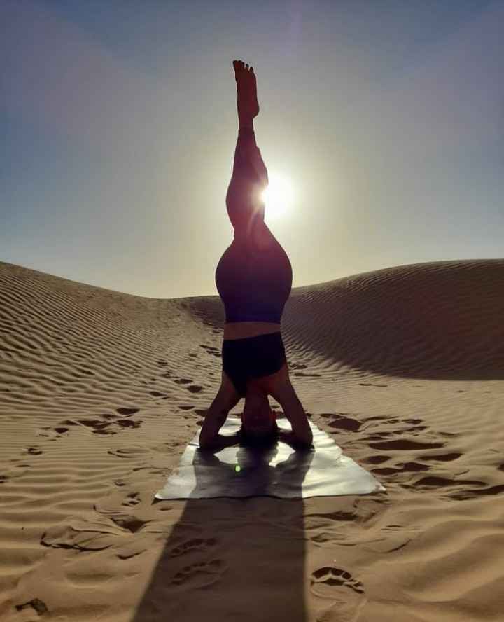 Yogapose und Kopfstand in der Wüste