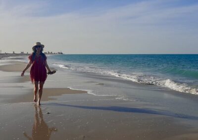 Frau läuft am Strand und blaues Meer im Hintergrund