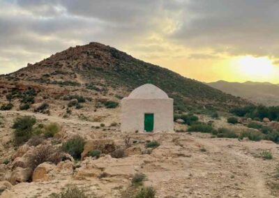 Berg im Sonnenuntergang mit kleinem weißen Kuppelhaus davor, in Tunesien Marabout genannt.