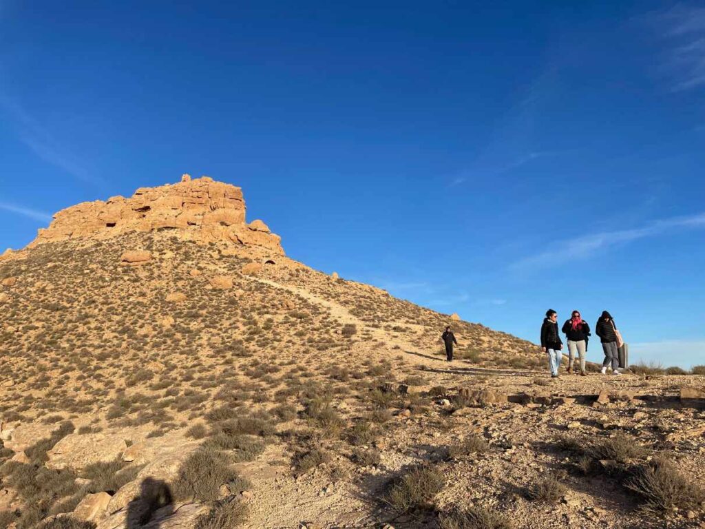 Ein Tafelberg vor klarem blauen Himmel mit kleinern Wandergruppe davor