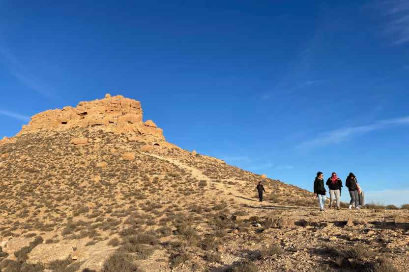 Berg mit blauem Himmel und Wandergruppe davor