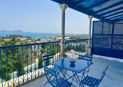 Terrasse mit blauen Möbeln und arabisch verziertem Gitter