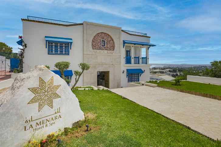 Hotel hinter blauem Himmel Zufahrt von Rasen gesäumt