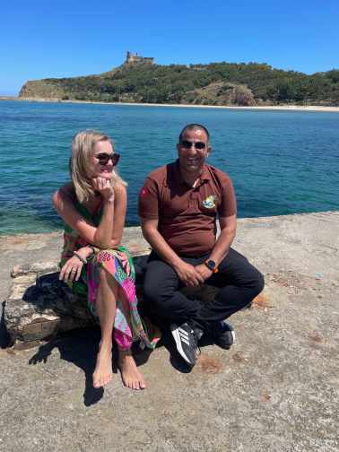 Mann und Frau auf Bank und mit Blick auf Insel